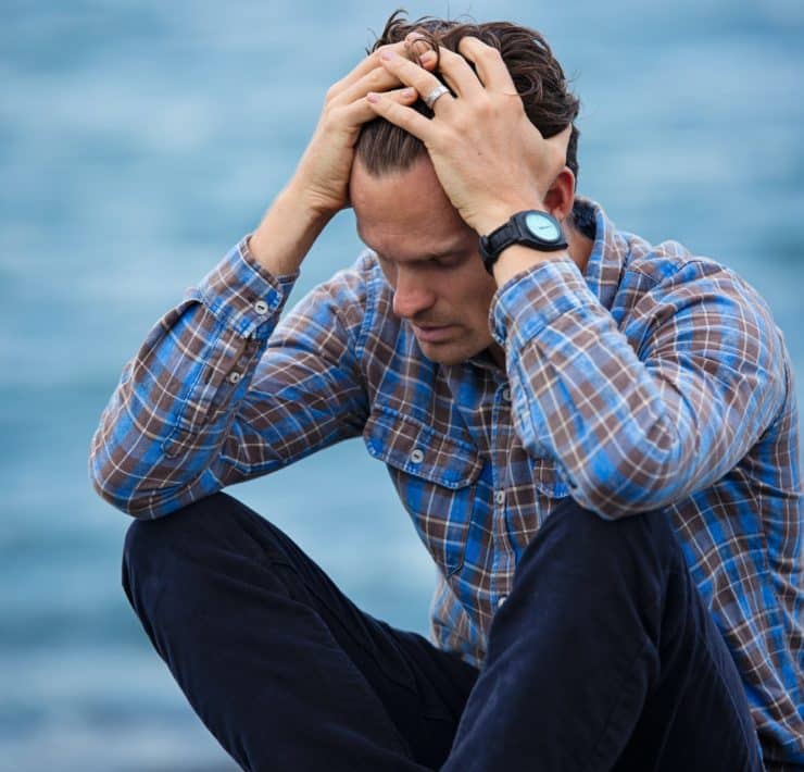 man in blue and brown plaid dress shirt touching his hair 897817
