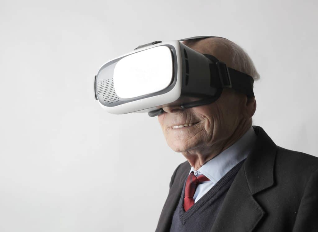 senior man using vr goggles in studio 3831136