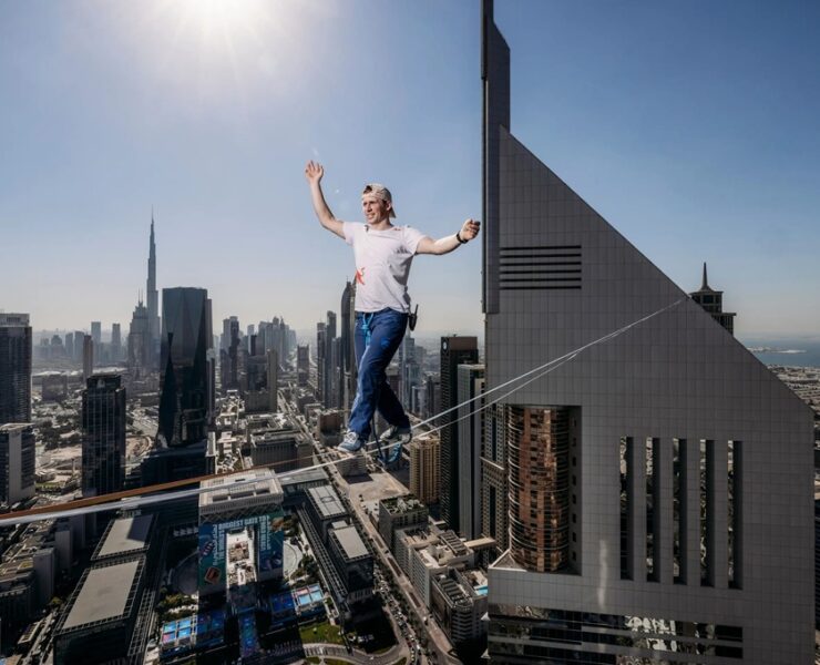 daredevil takes a stroll between two towers at a height of over 700 ft