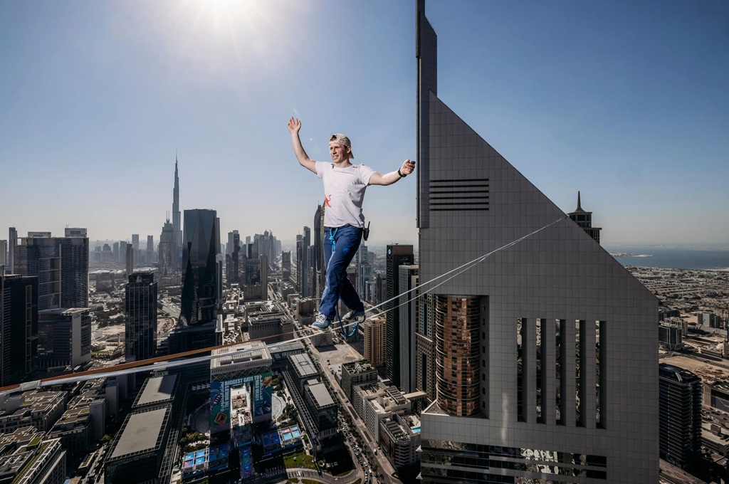 daredevil takes a stroll between two towers at a height of over 700 ft